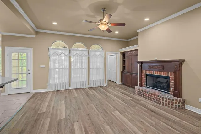 wooden floor fireplace and windows in an empty room