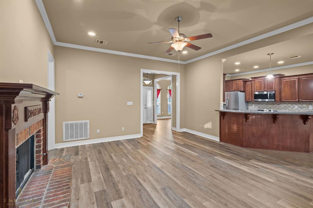 1940 Honeytree Trail Haughton, LA 71037 - Photo 10 of 21 a view of an empty room with wooden floor and a kitchen