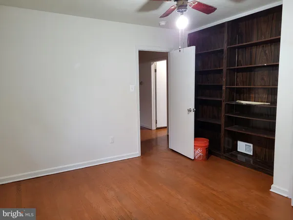 a view of an empty room with a cabinet and a ceiling fan