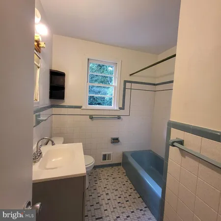 a bathroom with a sink toilet and window
