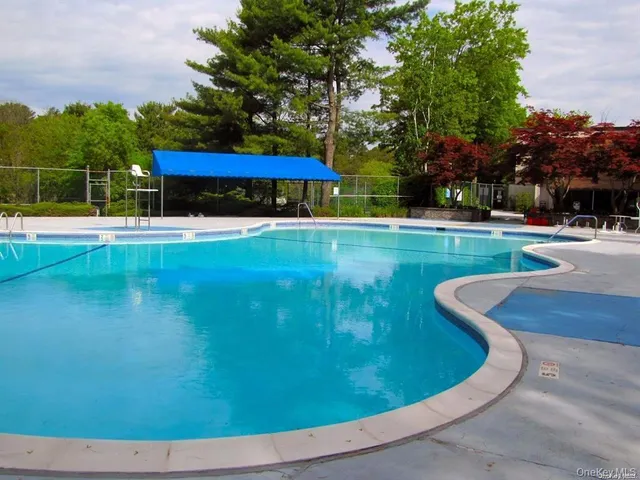 a view of a swimming pool with a yard and sitting area