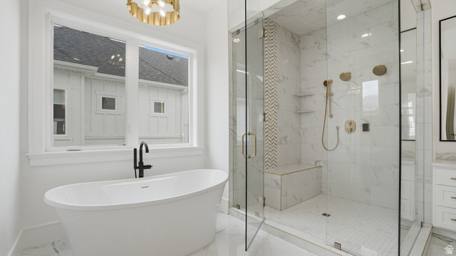 1682 North 1950 W Street, Unit 9 Provo, UT 84604 - Photo 31 of 84 Freestanding soaking tub with a matte black faucet, full glass shower enclosure with a built-in bench, marble-finish tile, and brass shower fixtures