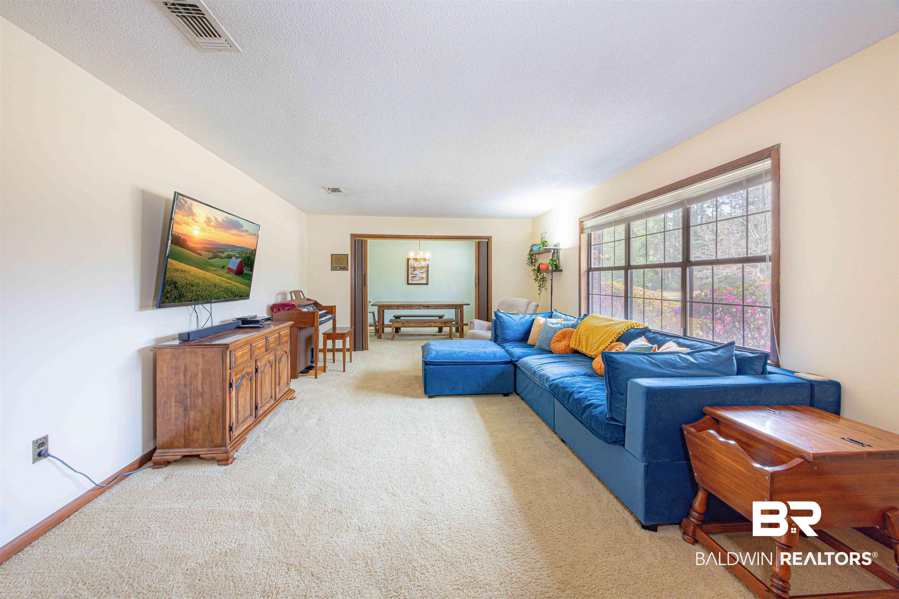 47580 Rabun Road Bay Minette, AL 36507 - Photo 7 of 55 Living area with visible vents, light carpet, a textured ceiling, and an inviting chandelier