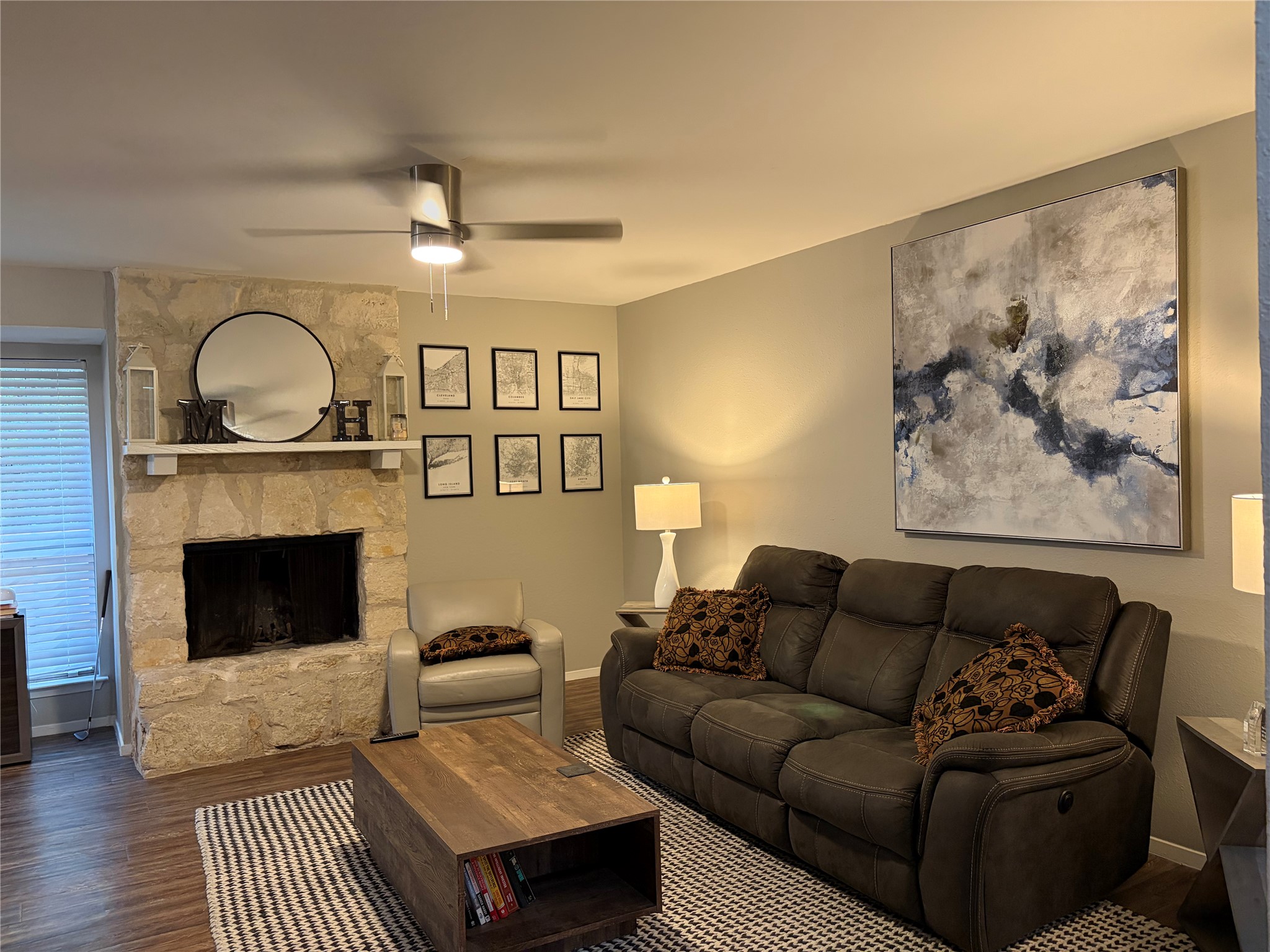 1400 Vista Ridge Cove, Unit B Austin, TX 78754 - Photo 5 of 25 A comforting living space features a commanding stone fireplace and dark wood-style flooring.