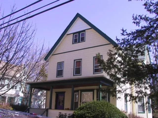 a view of a house with a yard and potted plants