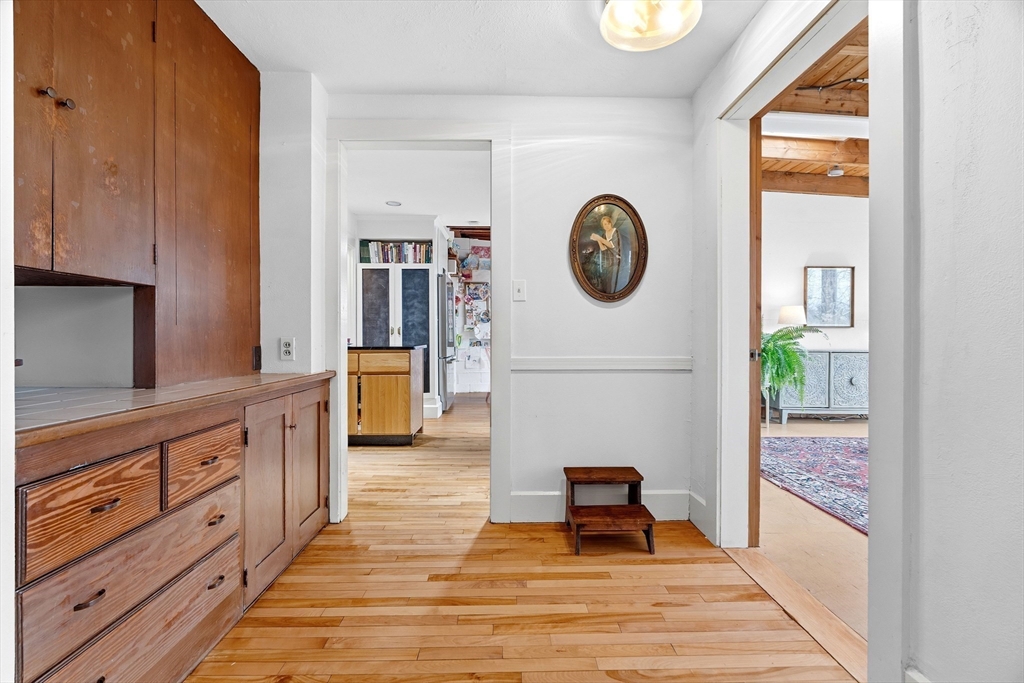 61 Huntington Road Newton, MA 02458 - Photo 12 of 41 a hallway with mirror and a wooden floor