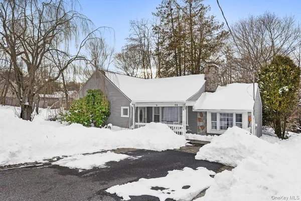 a front view of a house with a yard covered in snow