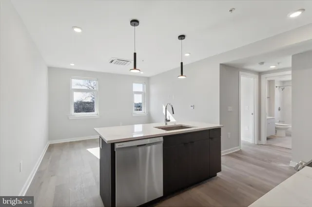a kitchen with stainless steel appliances granite countertop a sink a window and wooden floor