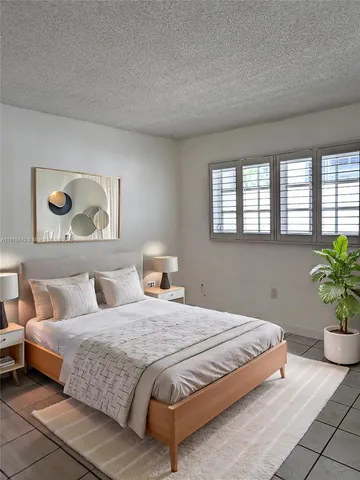 a bedroom with bed and a potted plant