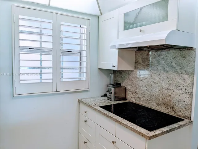 a kitchen with a stove cabinets and a window