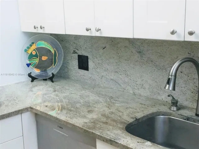 a close view of a sink and a granite counter top a stove
