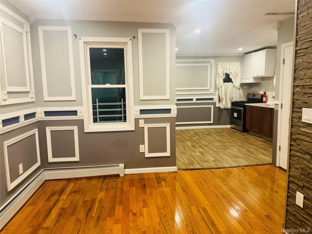 a view of a kitchen with wooden floor and electronic appliances