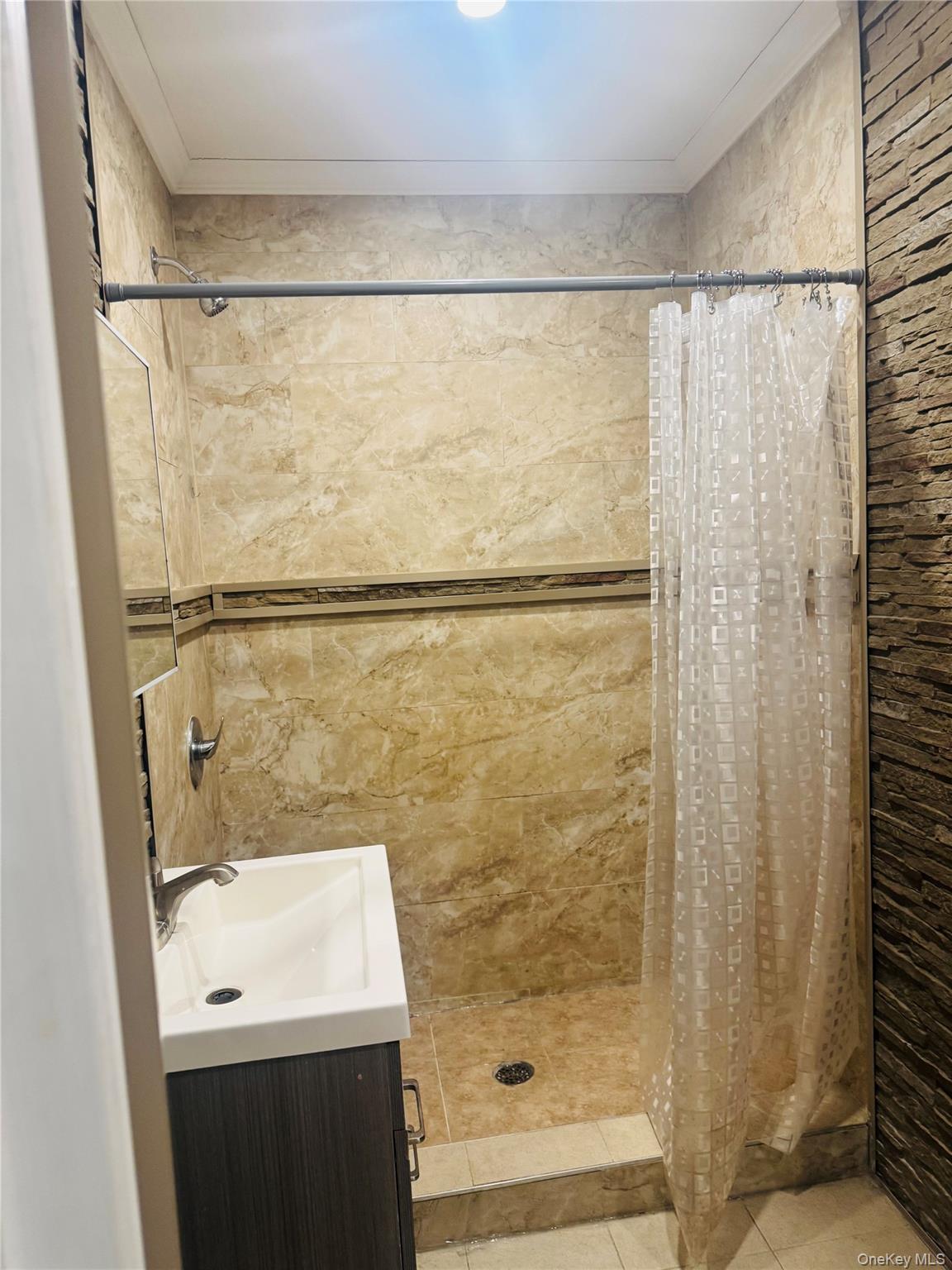 80-33 88th Road, Unit 2 Queens, NY 11421 - Photo 6 of 6 a bathroom with a shower a sink and a mirror