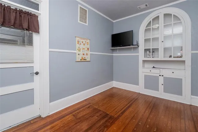 a view of a livingroom with wooden floor and a flat screen tv