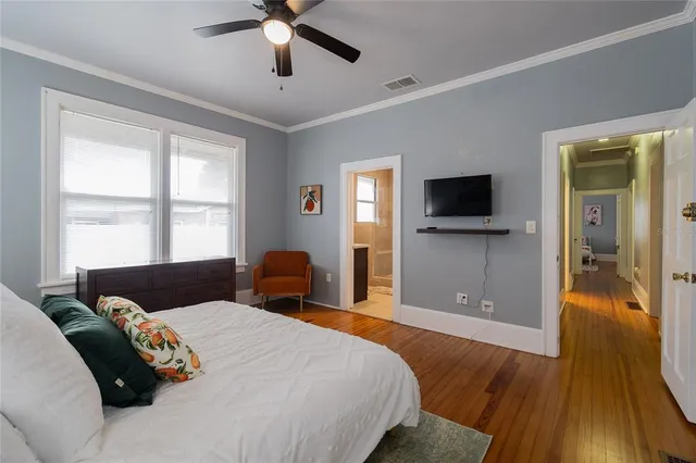 a bedroom with a bed and a flat tv screen on dresser