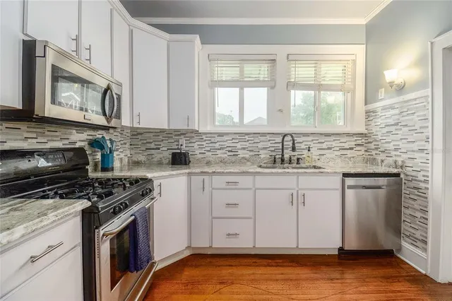 a kitchen with granite countertop a stove sink and cabinets