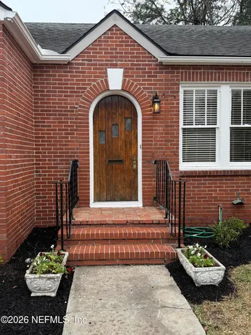 a view of empty room with fireplace and wooden floor