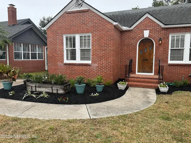 a view of a livingroom with wooden floor a fireplace and windows
