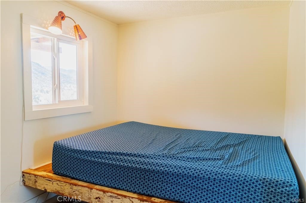 48317 Burns Canyon Road Pioneertown, CA 92268 - Photo 14 of 41 a bedroom with a bed and a window