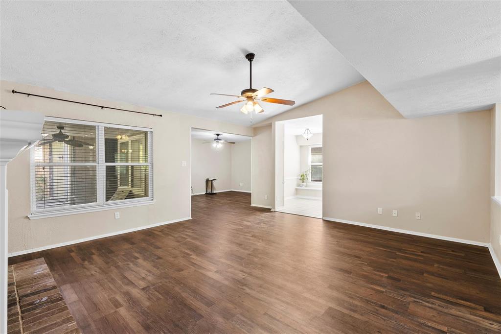9212 Shipman Street Rowlett, TX 75088 - Photo 14 of 34 Unfurnished living room featuring dark wood finished floors, a ceiling fan, and healthy amount of natural light