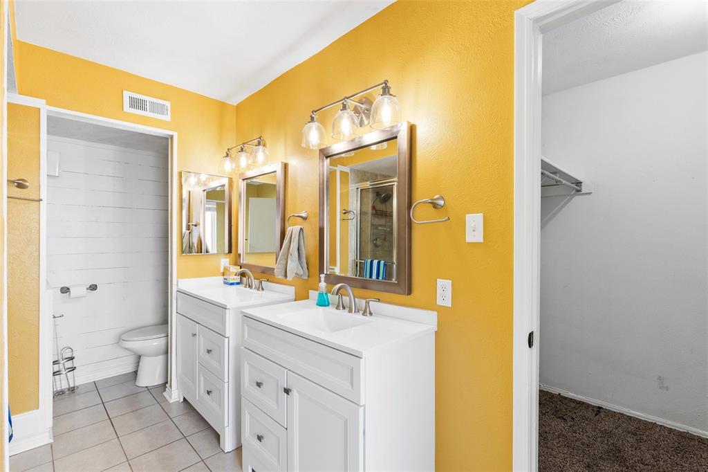 9212 Shipman Street Rowlett, TX 75088 - Photo 20 of 34 Primary bathroom with two vanities, a walk in closet, a shower stall and light tile patterned floors