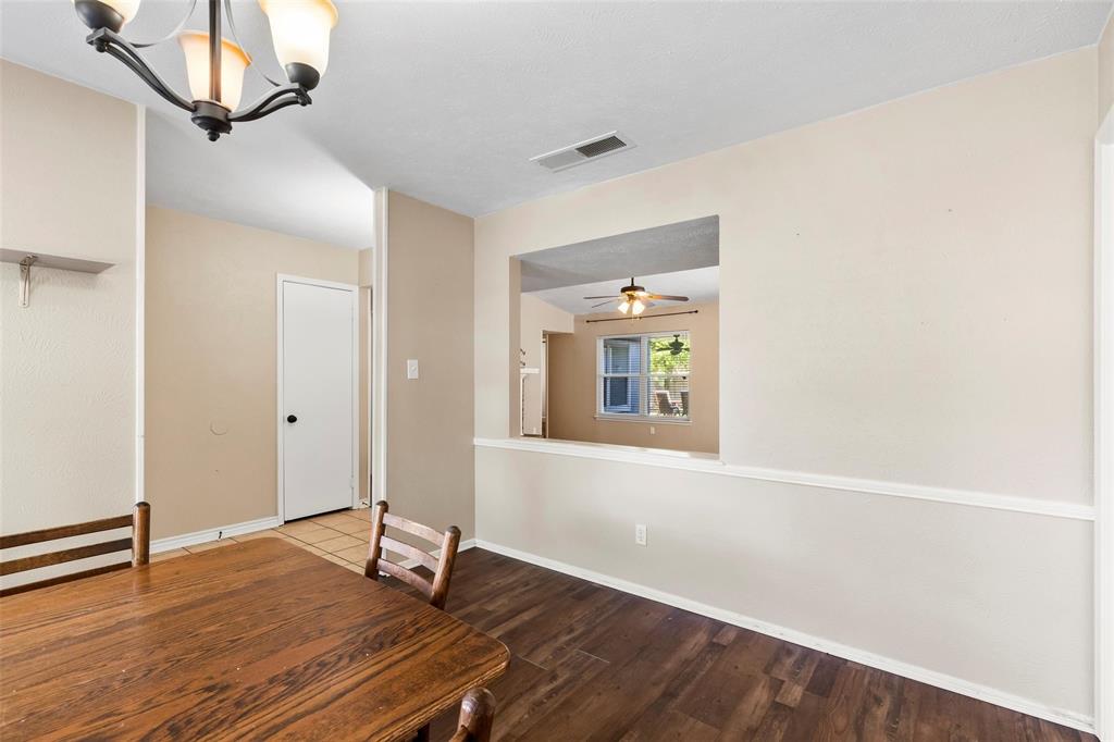 9212 Shipman Street Rowlett, TX 75088 - Photo 6 of 34 Dining area featuring wood finished floors, a chandelier looking into living room with a ceiling fan
