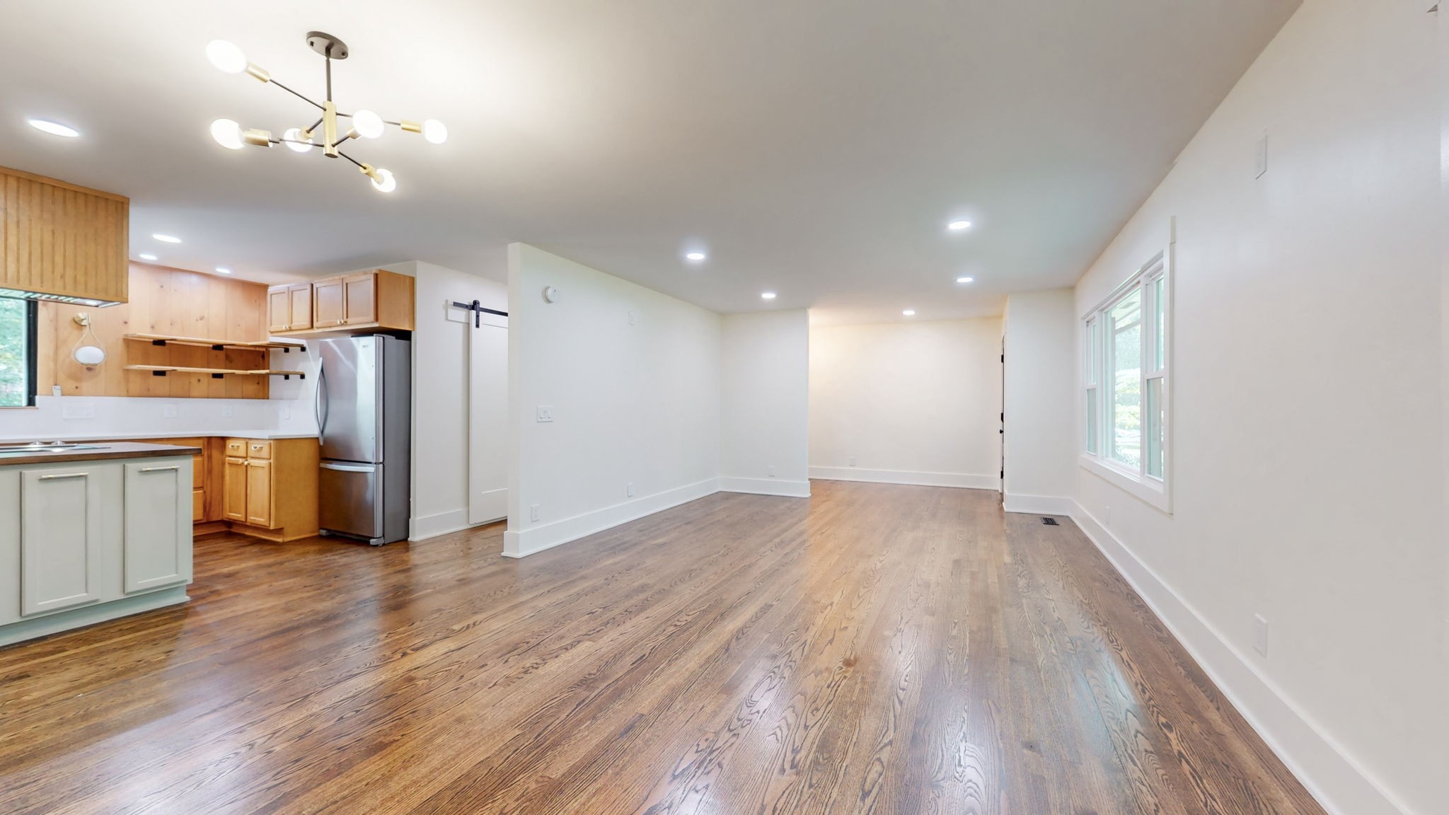 196 Thomas Street Manchester, TN 37355 - Photo 11 of 43 an empty room with wooden floor kitchen view and a window
