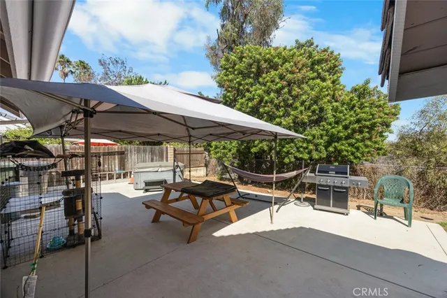a view of a patio with a table and chairs under an umbrella