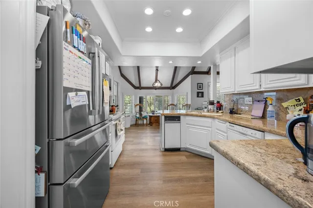 a kitchen with granite countertop a refrigerator a sink and a stove top oven