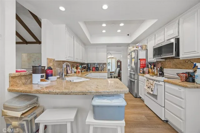 a large kitchen with stainless steel appliances granite countertop a sink and cabinets