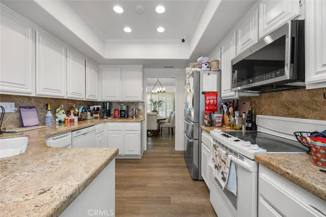 a kitchen with stainless steel appliances granite countertop a sink dishwasher stove and microwave with wooden cabinets
