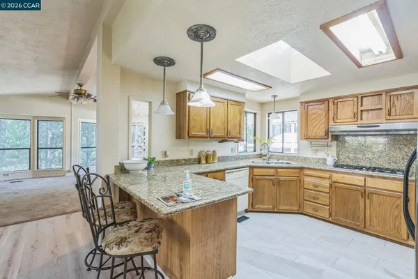 a kitchen with granite countertop a sink stainless steel appliances and cabinets