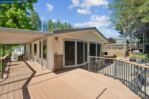 a backyard of a house with barbeque oven and large trees