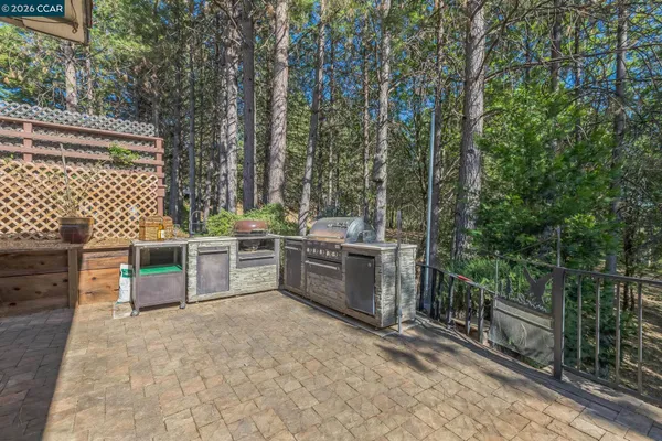 a backyard of a house with barbeque oven outdoor seating and yard in the back