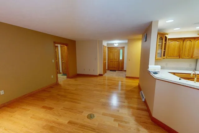 a view of a kitchen with kitchen island a sink wooden floor and living room view