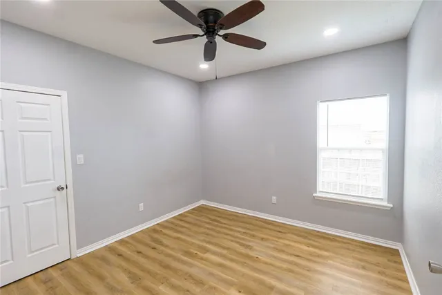 an empty room with windows and fan