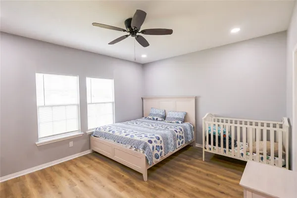 a bedroom with a bed a window and a ceiling fan