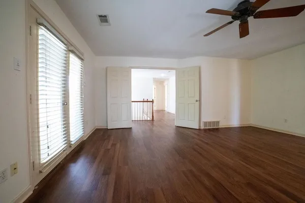 a view of empty room with wooden floor and window