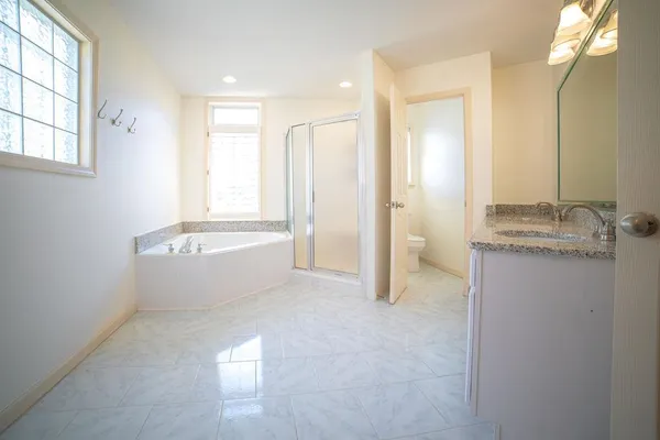 a bathroom with a tub sink and mirror