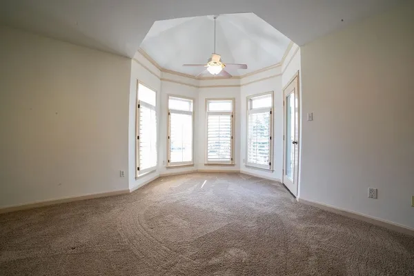 an empty room with windows and chandelier