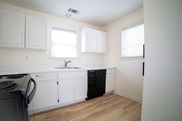 a kitchen with a sink window and cabinets