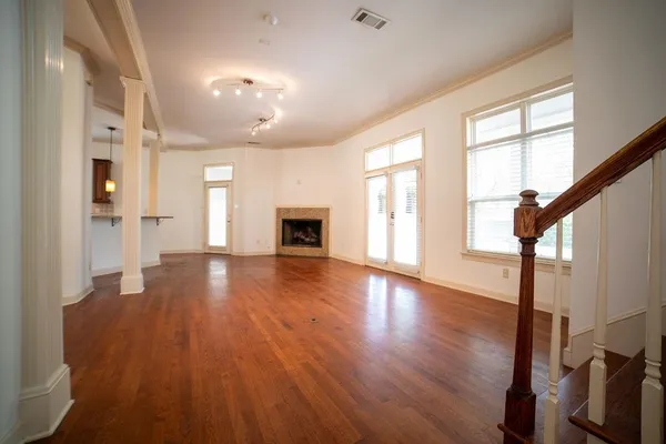 a view of empty room with wooden floor and fireplace