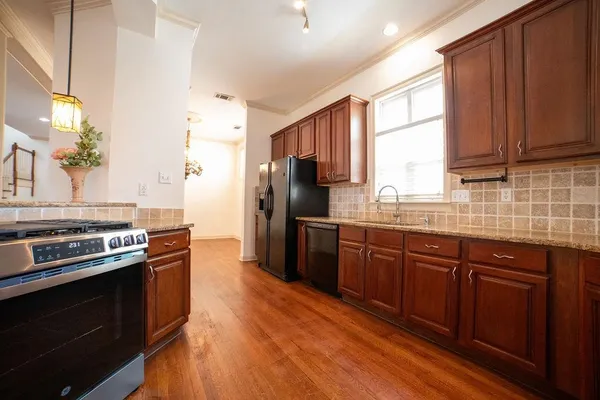a kitchen with stainless steel appliances granite countertop a stove a refrigerator and a sink