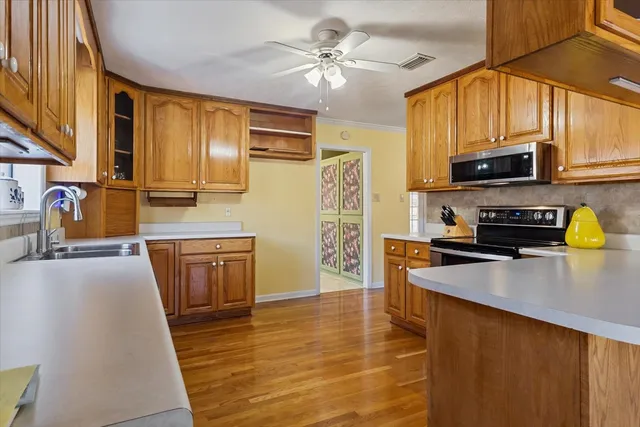 a kitchen with stainless steel appliances a stove a sink and cabinets