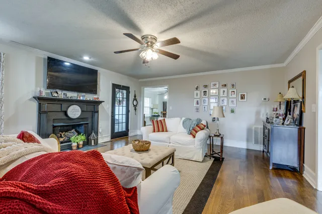 a living room with furniture fireplace and chandelier