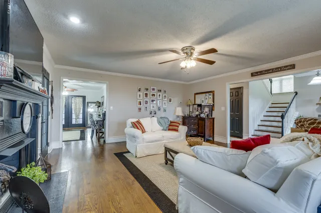a living room with furniture flat screen tv and a large window