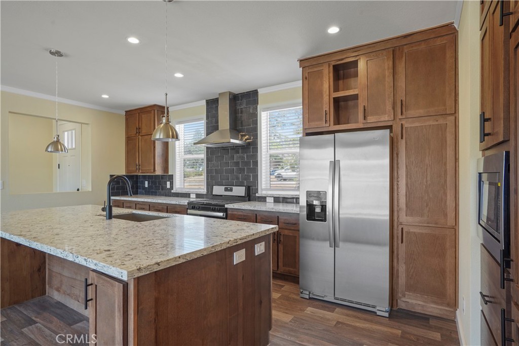 a kitchen with stainless steel appliances granite countertop a sink a refrigerator and a granite counter tops