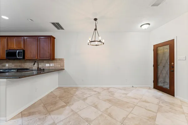 a kitchen with granite countertop a refrigerator and a stove top oven