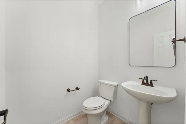 a bathroom with a sink a toilet and mirror