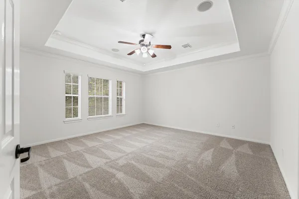an empty room with windows and ceiling fan view